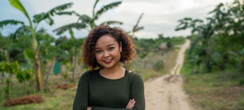 A woman standing in a field, smiling